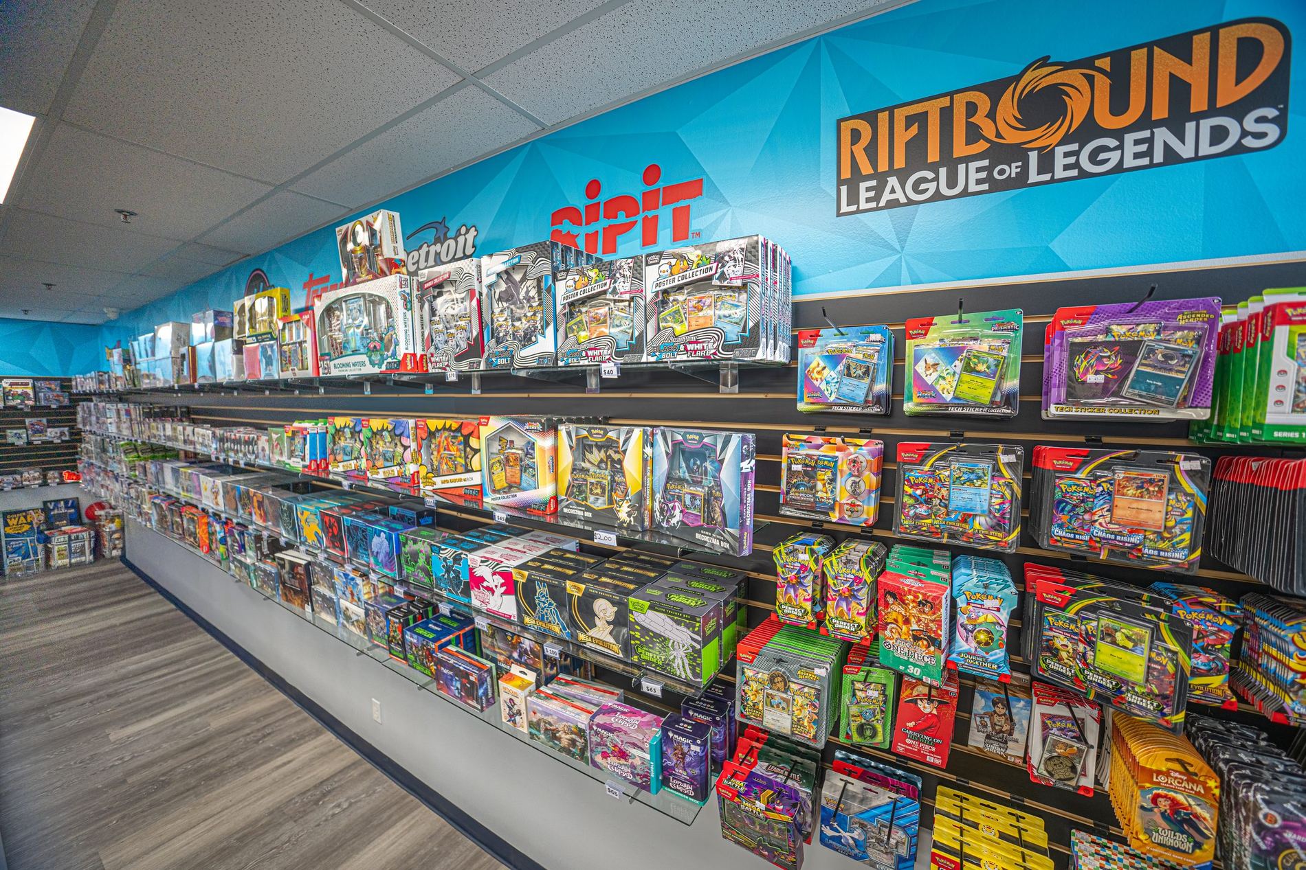 Shelves of sealed trading card products lining the wall at Hidden Gems Card Shop